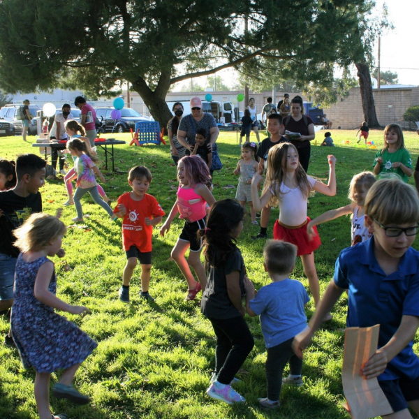 photo of children dancing on a lawn